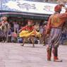 The hunter Gonpo Dorje, his dog and atsara, dance of Milarepa (Sha ba sha khyi 'cham), Paro Tshechu (tshes bcu), dance arena, Paro Tshechu (tshes bcu), 2nd day