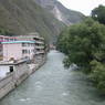 Houses and trees along river in downtown Derge [sde dge] .