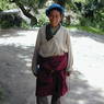 A Tibetan man wearing a chuba and holding a rosary.