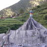 Top part of stupa made of prayer flags and prayer stones in the outskirts of Derge.