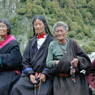 Tibetan women wearing black chubas and using rosaries.