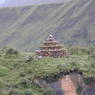 A stupa made of a rock pile on top of a small hill.