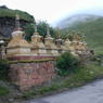 A row of stupas along the roadside.