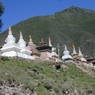 A row of stupas along a road.