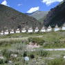 A row of stupas alongside a road.