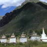 One end of a long row of stupas set alongside a road.
