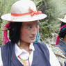 Tibetan woman wearing hat and turquoise hair ornament.