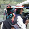 Tibetan women wearing hats, braids, and turquoise hair ornaments.