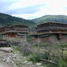Tibetan log houses with woven brush shading devices on the second story.