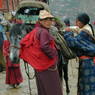 A Tibetan nun and nomad woman loading a horse.