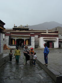 Tibetan children and western woman at the entrance to the monastery.