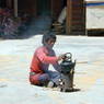A nomad boiling water in the courtyard of the residence of Khenpo Jigme Phuntsok, the founder of Larung Gar.