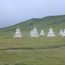 A group of white stupas near the road.