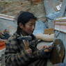 A Tibetan girl carving a prayer stone.