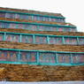 Painted carvings of buddhas framed in a pile of prayer stones. ??
