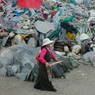 A Tibetan woman and child circumambulating the pile of prayer flags and stones.