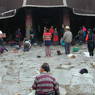 Tibetans prostrating in the courtyard before the entrance portico of the temple.