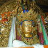 A Buddha statue adorned with silk scarves.