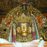 A Buddha statue adorned with silk scarves.