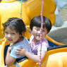 Young Tibetan girls on an amusement park ride.