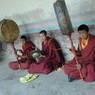 Monks playing pole drums and cymbals in the courtyard.