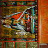 A statue of Padmasambhava adorned with silk scarves and other offerings.