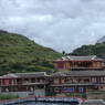 Tibetan houses and a stupa on a hillside.