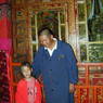 A young Tibetan-American girl and a monk caretaker in front of one of the palace's shrines.