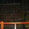 Shelves of traditional Tibetan texts and an ornately decorated stupa inside the Assembly Hall.