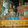 A statue of a Sakya lama flanked by a butter and flour sculpture of the Eight Auspicious Signs.