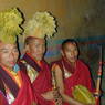 Monk musicians dressed up with yellow hats.