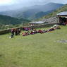A view of the audience seated in the courtyard with the valley in the background.