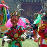 Masked dancers performing in the courtyard.
