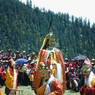The audience stands up as the Padmasambhava dancer and his retinue process around the courtyard.