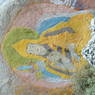 A painted rock carving of a Geluk religious sect lama.