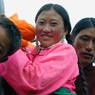 Close up of a Tibetan woman wearing a pink shirt.
