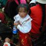A young Tibetan girl holding a Pepsi bottle.