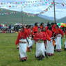A troupe of dancers with red shirts preparing to perform.