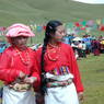 Two young Tibetan women wearing red shirts.