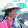 A close up of a young Tibetan woman wearing a pink shirt.