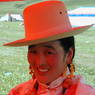 A Tibetan woman resting under a red umbrella.