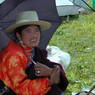A Tibetan woman resting under an umbrella.