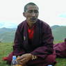 A monk eating on top of the hill.