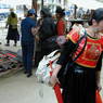 A stylishly dressed Chinese woman looking at a merchant's wares.