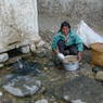 Woman washing barley at village water source