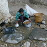 Woman washing barley at village water source