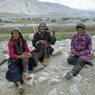 Three village woman relaxing in front of village