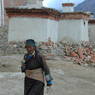 Woman with prayer wheel and rosary circumabulating village