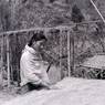 Gurung woman sifts grain drying on straw mat