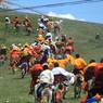 Tibetan men racing horses at Lhagang horse festival.